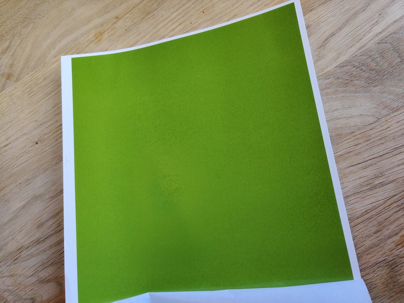 May include: A solid green sheet of paper with a slightly textured surface.
