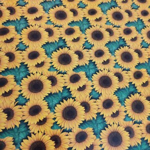May include: A teal background with a repeating pattern of yellow sunflowers. The sunflowers have dark brown centres and yellow petals.