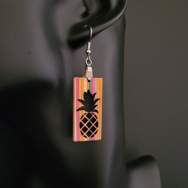 Pineapple dangling earrings handmade from recycled skateboards wood . Stainless steel ears wires .