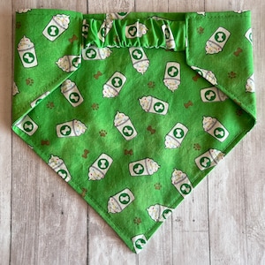 May include: Green dog bandana with a white and brown print of coffee cups and paw prints.
