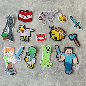 Könnte beinhalten: Eine Sammlung von aufgestickten Minecraft-Patches. Die Patches zeigen Charaktere und Gegenstände aus dem Spiel, darunter ein TNT-Block, ein Wolf, eine Biene, ein Schwert, eine Spitzhacke, ein Creeper und Spielfiguren.