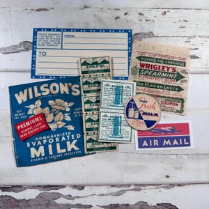 May include: A collection of vintage ephemera, including a blue and white post card, Wilson's Evaporated Milk label, Wrigley's Spearmint gum wrapper, Eagle stamps, a Pure Fresh Milk label, and an Air Mail sticker.