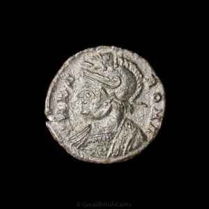 Op de afbeelding: Een zilveren Romeinse munt met een portret van een man met een helm. De munt heeft een verhoogde rand en is licht beschadigd.