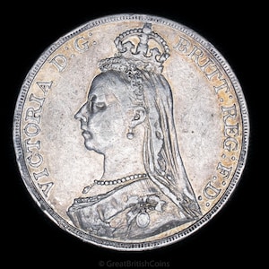 May include: A silver coin featuring a profile of a woman wearing a crown and veil, with the inscription "VICTORIA D.G. BRITT. REG. F.D." around the edge. The coin has a detailed design and a slightly worn appearance, set against a black background.
