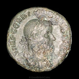 Puede incluir: Una moneda romana de plata con la inscripción "IMP.  COPTN" alrededor del borde. La moneda presenta un perfil de un hombre con una corona de laurel en la cabeza.