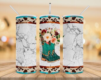 May include: A white marble tumbler with a turquoise and brown patterned band at the top and bottom. The tumbler features a floral bouquet with turquoise cowboy boots.