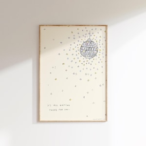 May include: A framed art print with a hand-drawn illustration of a disco ball. The artwork includes the text "IT'S ALL WAITING THERE FOR YOU..." and is surrounded by small, colourful shapes. The frame is a light brown colour.
