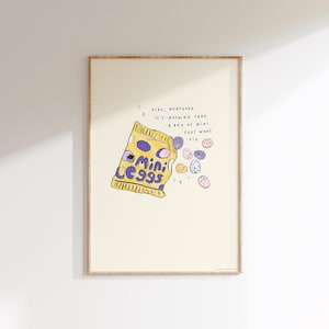 May include: A framed print with a cartoon-style illustration of a yellow bag of "Mini Eggs" sweets. The text reads "Girl, whatever, it's nothing that a bag of Mini Eggs won't fix." Scattered eggs in various colours are also shown.