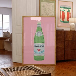 May include: A pink framed poster with a white cloud above a green glass bottle of sparkling water with a red star and the text "SPELLEGRINO" on the label.