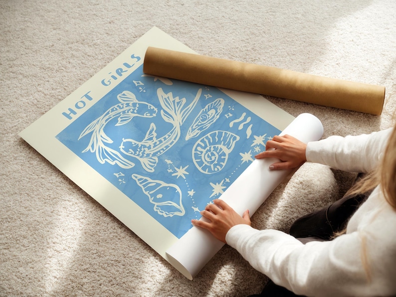 Puede incluir: Un p&oacute;ster blanco con fondo azul que presenta un dise&ntilde;o de peces, conchas y estrellas. El p&oacute;ster tiene el texto "HOT GIRLS" impreso en blanco en la parte superior.