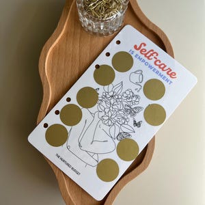 Self Care Mystery Gratta e Risparmia: Raccoglitore con fori per il budget personale