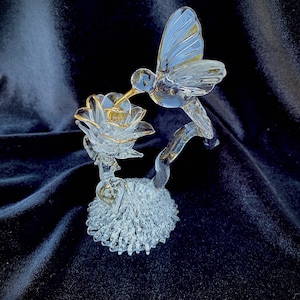 Blown glass hummingbird drinking from a rose
