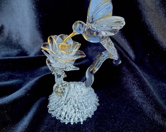 Blown glass hummingbird drinking from a rose