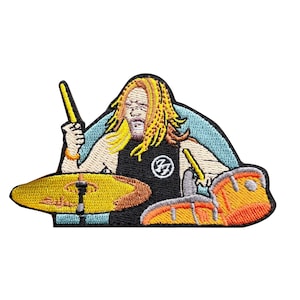 May include: Embroidered patch showing a drummer with long, yellow hair and a black shirt. The patch depicts the drummer playing a yellow cymbal and orange drum set with yellow drumsticks. The patch has a light blue background.