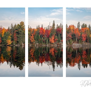 Peut inclure: Une vue panoramique d'un lac reflétant les couleurs vibrantes du feuillage d'automne. Les arbres sur la rive sont un mélange de vert, jaune, orange et rouge, créant un magnifique spectacle de couleurs d'automne. L'eau est calme et immobile, reflétant parfaitement les arbres et le ciel.