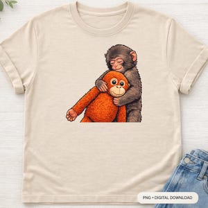 Op de afbeelding: Beige t-shirt met een cartoon illustratie van twee apen die elkaar omhelzen. Eén aap is bruin en de andere is oranje. De afbeelding is een digitale download.