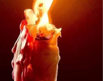 May include: A lit candle with a bright yellow flame against a dark red background. The candle is ivory-colored with red wax dripping down its sides, creating a textured appearance. The flame is tall and bright.