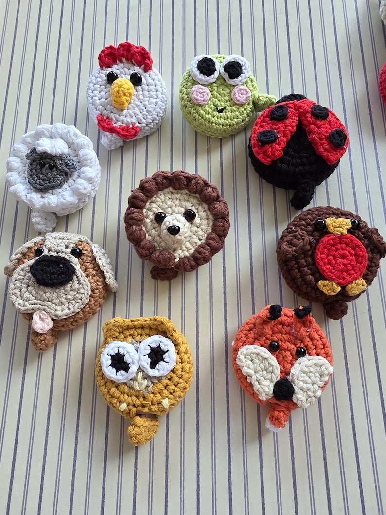 May include: A collection of handmade crochet animal ornaments, including a chicken, frog, ladybug, sheep, dog, lion, owl, fox, and bird. Each ornament features detailed stitching and vibrant colors, perfect for children's decor or craft projects.