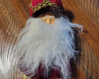 Enfeite vintage dos anos 90 com cabeça de Papai Noel e bobo da corte, ideal para o topo da árvore. Visual bacana.