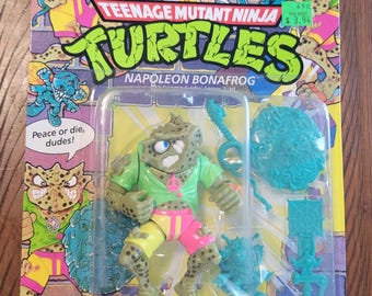 Figura de ação vintage das Tartarugas Ninja, Napoleon Bonafrog, de 1990, em bom estado e lacrada.