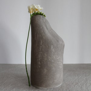 グレーのユニークな彫刻的な花瓶 侘び寂びスタイルのストーンウェア 手作り陶器の花瓶 落ち着いた色でデザインされたミニマルなスタイル 装飾的な花瓶