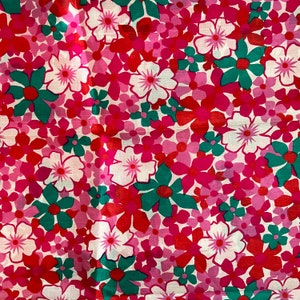 May include: A pink and red floral fabric with a repeating pattern of flowers and leaves. The flowers are in shades of pink, red, and white, and the leaves are green.