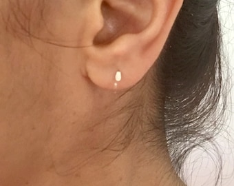 Un par de pequeños aros de plata de ley, oro amarillo o rosa con forma de lágrima de alambre martillado.