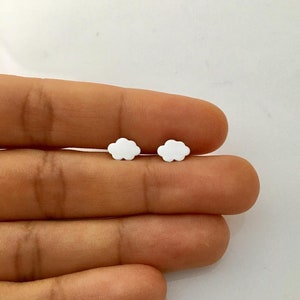 May include: A pair of white cloud-shaped stud earrings.