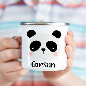 Puede incluir: Taza de camping de esmalte blanco con una cara de panda blanco y negro y el nombre Carson impreso debajo.