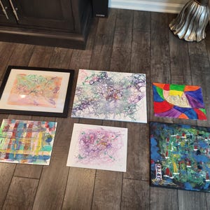 Puede incluir: Seis pinturas abstractas en varios colores y estilos, incluyendo una pintura enmarcada con un dise&ntilde;o rosa y verde, una pintura con un dise&ntilde;o azul y verde y una pintura con un dise&ntilde;o rojo, amarillo y morado.
