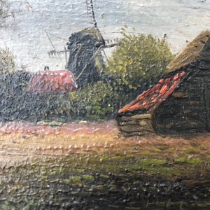 Op de afbeelding: Een schilderij van een landelijk landschap met een windmolen en een klein houten gebouw met een rood dak. De sc&egrave;ne is geschilderd in gedempte tinten bruin, groen en grijs.