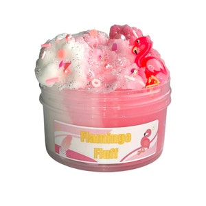 Puede incluir: Slime rosa y blanco con purpurina y chispas en un frasco transparente con un amuleto de flamenco rosa y una etiqueta que dice "Flamingo Fluff"