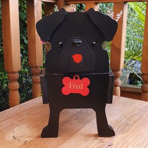May include: Black wooden planter shaped like a pug dog with a red nose and a bone-shaped tag that says "Fred".