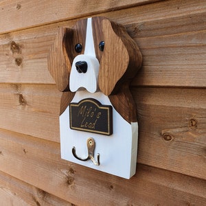 May include: Wooden dog head shaped wall hook with a black sign that says "Milo's Lead".