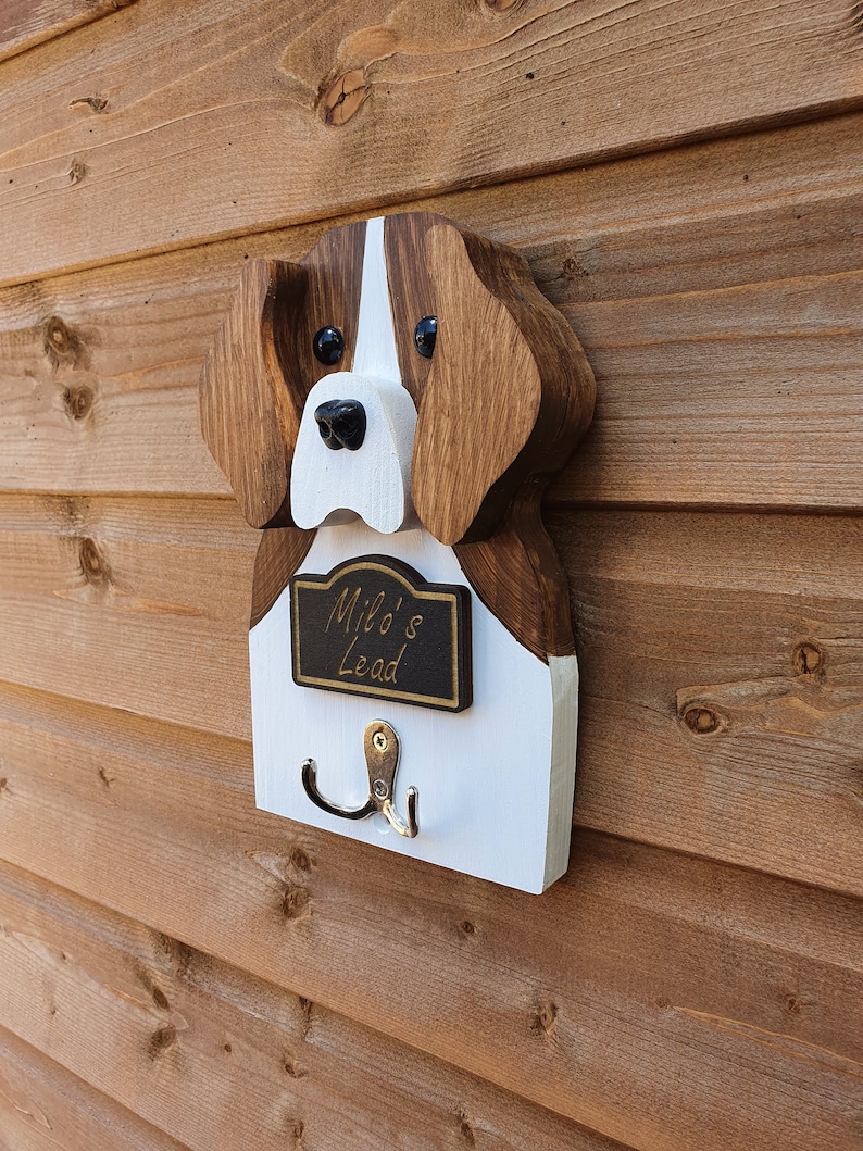 May include: Wooden dog head shaped wall hook with a black sign that says "Milo's Lead".