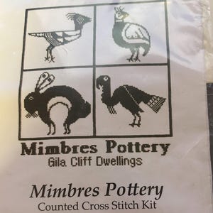May include: A counted cross stitch kit featuring four black and white animal designs. The kit includes the text "Mimbres Pottery" and "Gila Cliff Dwellings" above the text "Mimbres Pottery Counted Cross Stitch Kit".