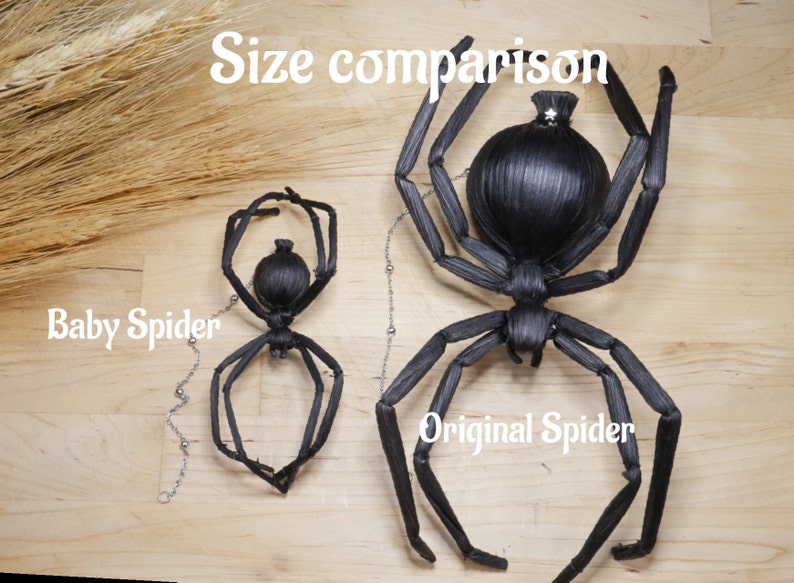 May include: Size comparison of two black spider sculptures. The larger spider is labeled "Original Spider" and the smaller spider is labeled "Baby Spider".