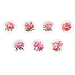 May include: Set of seven white ceramic plates, each featuring a watercolor illustration of a peony flower. The peonies vary in shades of pink and red, with green leaves. The plates are arranged in a circular pattern.