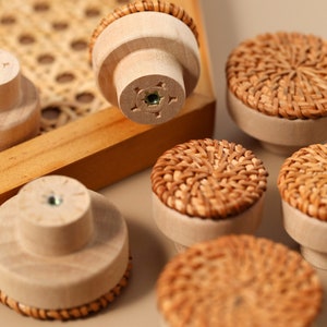 May include: A set of six wooden drawer pulls with woven rattan tops. The pulls are in various shades of brown and beige.
