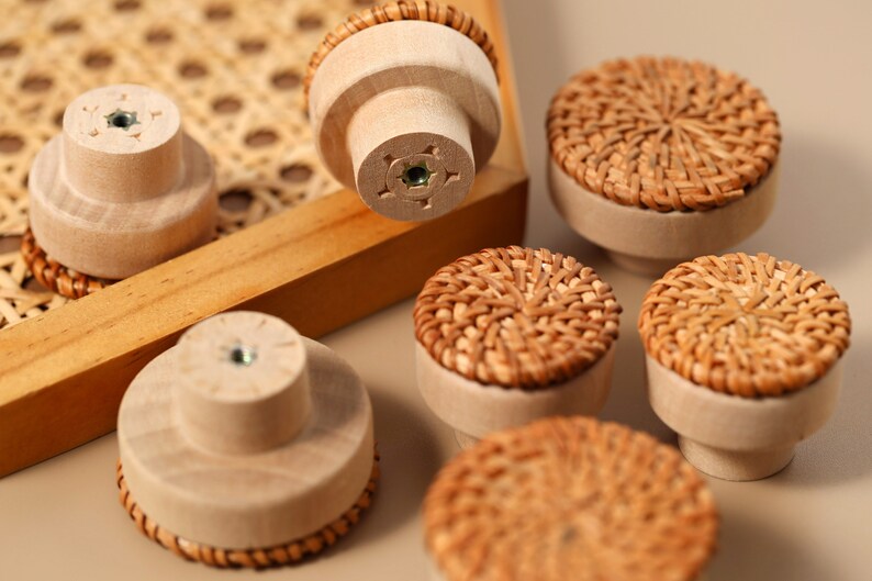 May include: A set of six wooden drawer pulls with woven rattan tops. The pulls are in various shades of brown and beige.