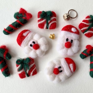 Può includere: Un set di addobbi natalizi in feltro, tra cui Babbo Natale, bastoncini di zucchero e regali. Gli addobbi sono rossi, verdi e bianchi.