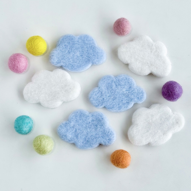 May include: A set of felt clouds in blue and white, with a variety of felt balls in different colors, including pink, yellow, green, purple, and brown.