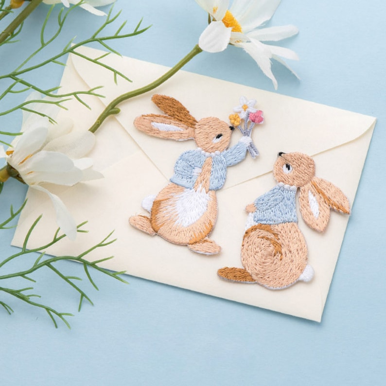 It's a series of embroidery bunny patches. Three styles are available. One is looking up, one is holding some flowers, and one is holding a carrot.