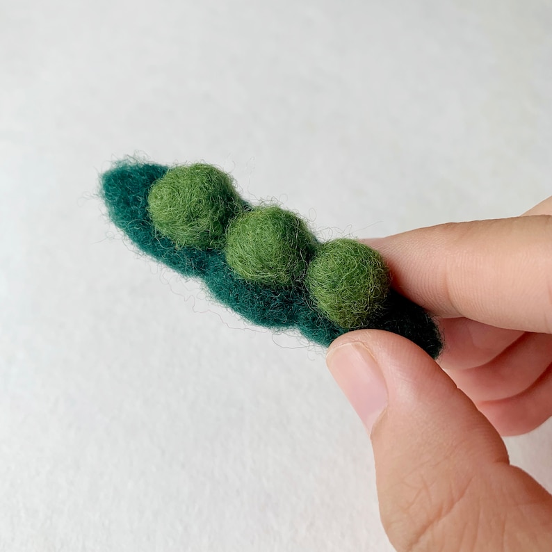 May include: A felt pea pod with three green felt peas inside.
