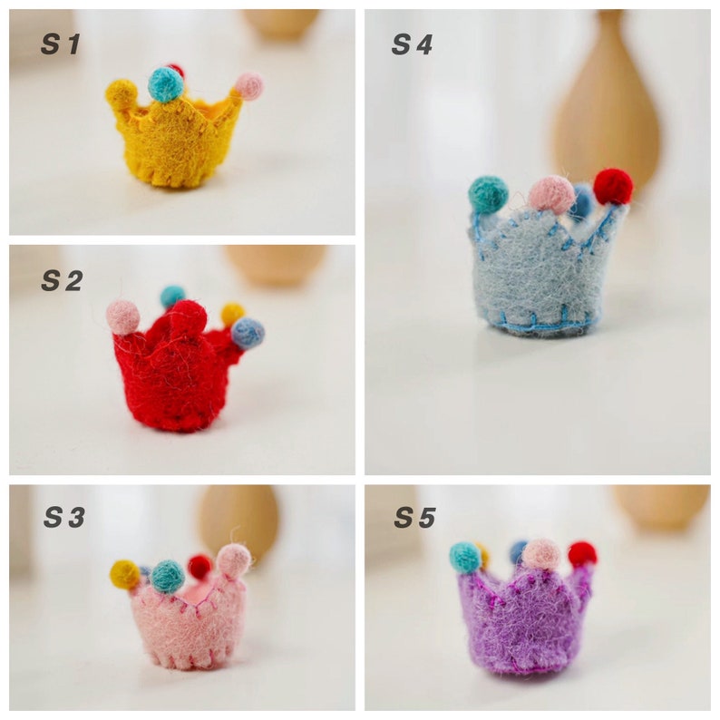 May include: Five small felt crowns labeled S1 through S5. S1 is yellow, S2 is red, S3 is light pink, S4 is light blue, and S5 is purple. Each crown features a scalloped top edge decorated with small, multi-colored felt pom-poms in various colors.