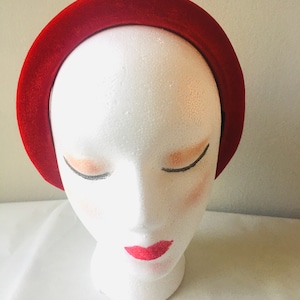 May include: A wide red velvet headband for women. The headband is made of soft, plush velvet and is designed to be comfortable to wear.