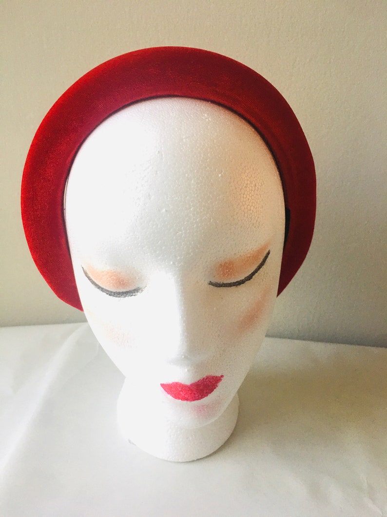May include: A wide red velvet headband for women. The headband is made of soft, plush velvet and is designed to be comfortable to wear.