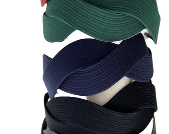 May include: Five braided headbands in different colors: red, green, navy blue, black, and gray. The headbands are made of a soft, stretchy material and are designed to be comfortable to wear.