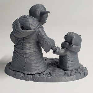 Peut inclure: Une figurine en 3D imprim&eacute;e en gris de Yoda et un Yoda plus petit, debout c&ocirc;te &agrave; c&ocirc;te sur une base grise. Le grand Yoda porte une robe et a une expression s&eacute;rieuse. Le petit Yoda regarde le grand Yoda.