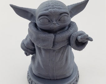 Puede incluir: Una figura gris impresa en 3D de un personaje con orejas grandes y una túnica, con el texto "THAT YOU SEE" en la base. La figura está sobre una superficie blanca.